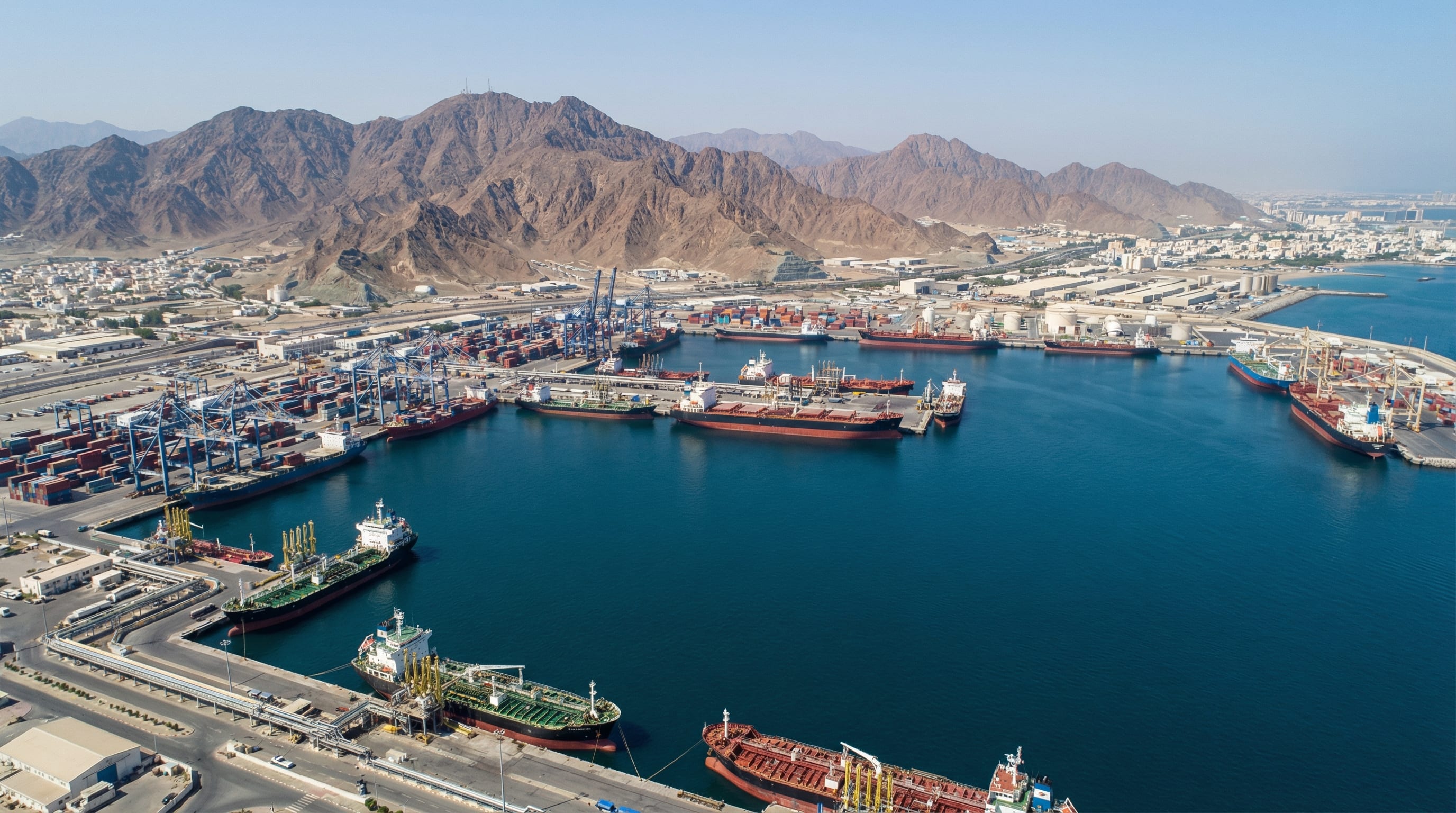 Port of Fujairah with cargo vessels and the Hajar Mountains in the background